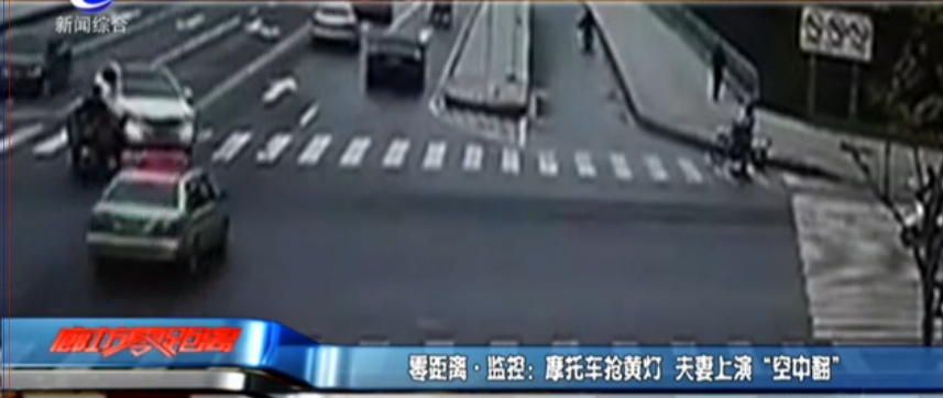 摩托车抢黄灯 夫妻上演“空中翻”