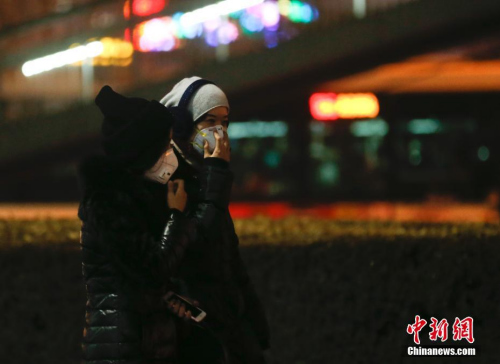 12月16日，北京民众戴防雾霾口罩出行。中新社记者 杜洋 摄