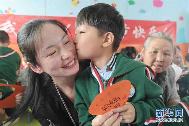 5月10日，在湖北省襄阳市一家幼儿园举办的母亲节主题活动中，一名小朋友将自己制作的贺卡献给妈妈。 新华社发（安富斌 摄）