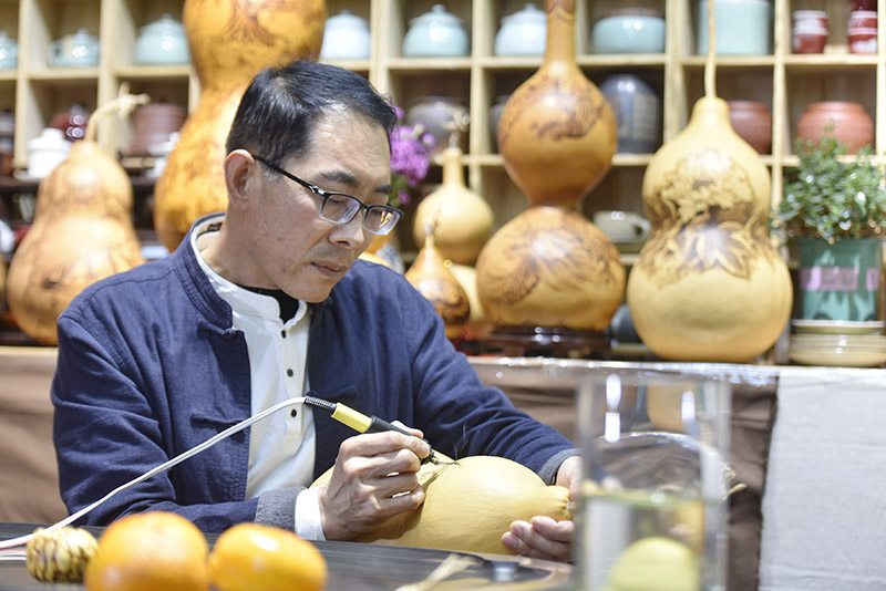 图为廊坊市广阳区吴氏葫芦烙画工作室内,吴宗正在绘制葫芦烙画作品。.jpg